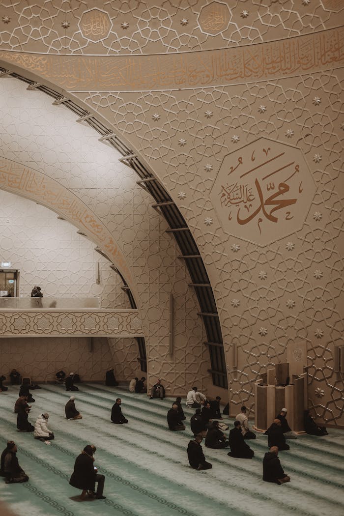 People kneeling in prayer at the beautifully ornamented Grand Mosque of Cologne.