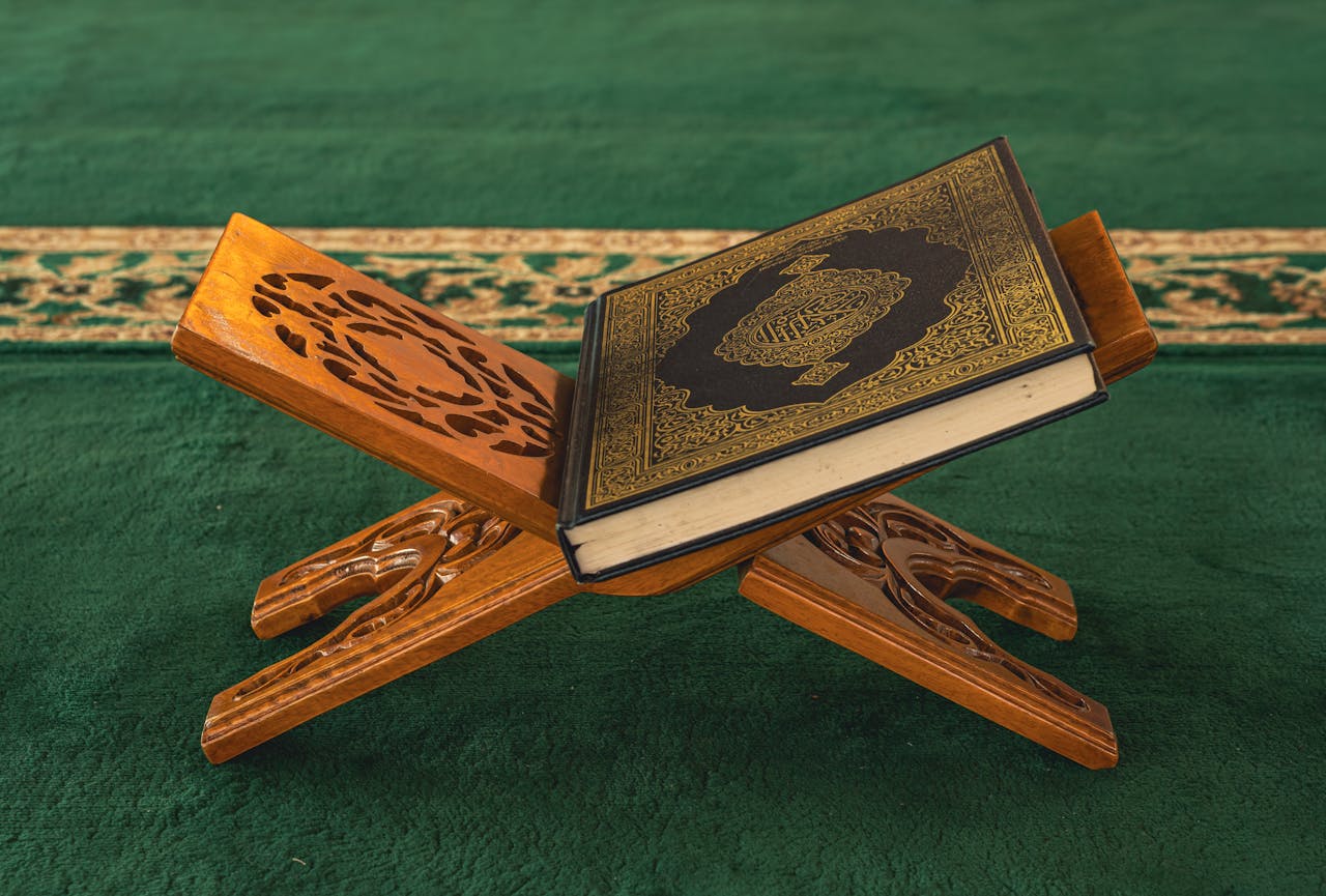A Quran rests on an intricately carved wooden stand in a mosque, showcasing Islamic artistry.