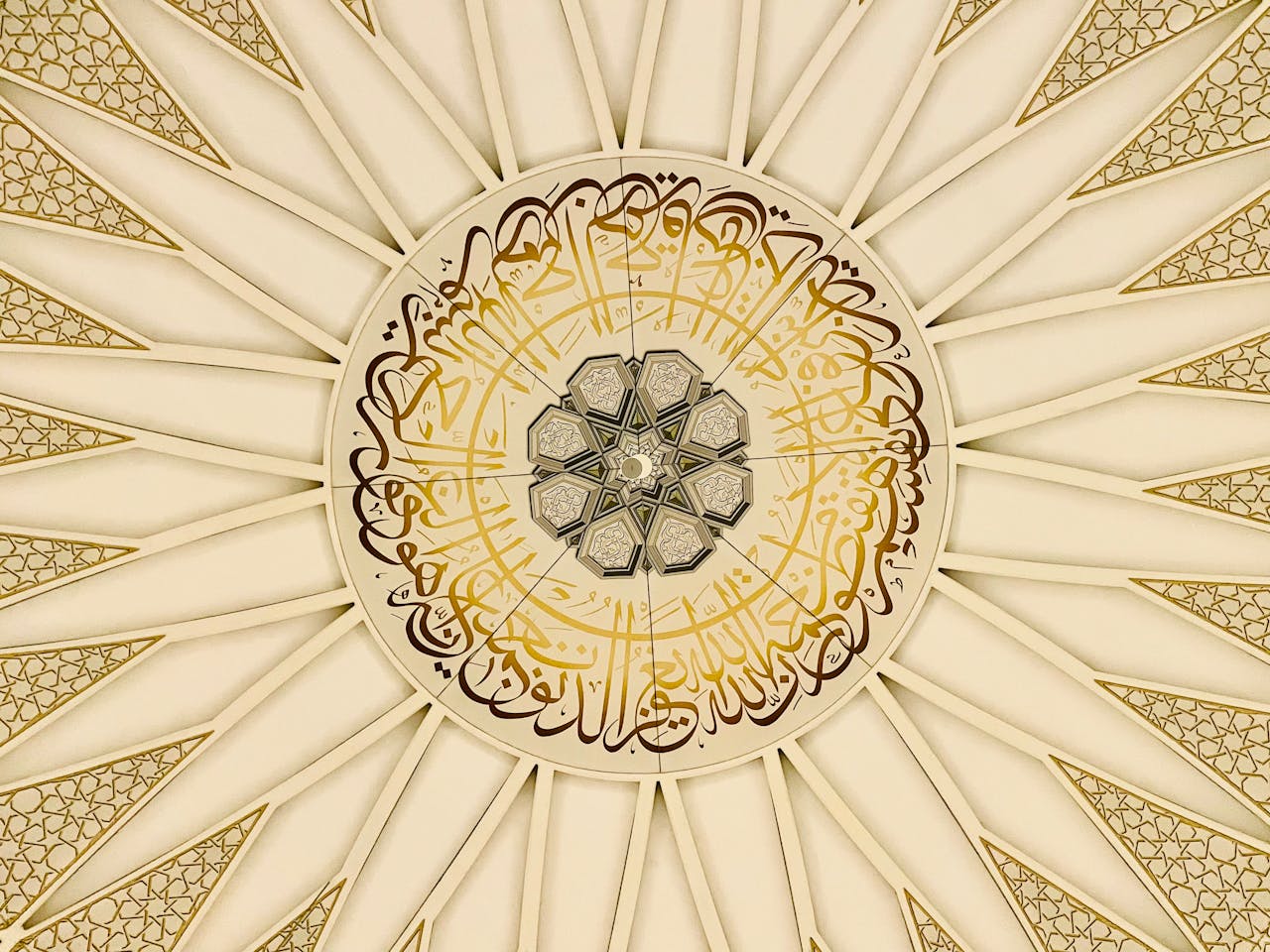 A detailed view of an ornate Islamic geometric ceiling design with Arabic calligraphy.